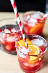 aperitif in the sports bar during a football match: Negroni cocktail with Campari, ice and orange slices, green and black olives