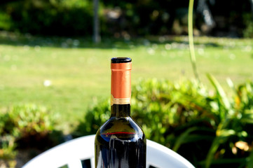 Eine Flasche Wein auf dem Tisch im Garten