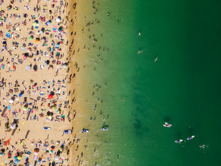 Fototapeta na wymiar Aerial View From Flying Drone Of People Crowd Relaxing On Algarve Beach In Portugal