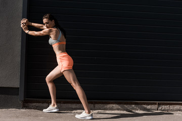 Fototapeta premium attractive sportswoman training in sportswear in city