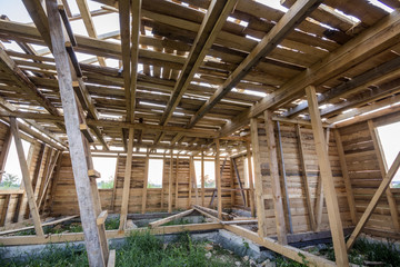 New wooden house under construction. Close-up of walls and ceiling frame with windows openings from inside. Ecological dream home of natural materials. Building, construction and renovation concept.