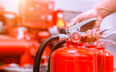 Close up Fire extinguisher and pulling pin on red tank. - obrazy, fototapety, plakaty