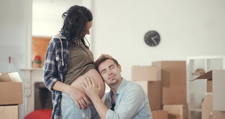 Father listens to the belly of his pregnant wife - Powered by Adobe