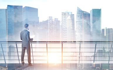 Fototapeta premium Businessman with papers on balcony, cityscape