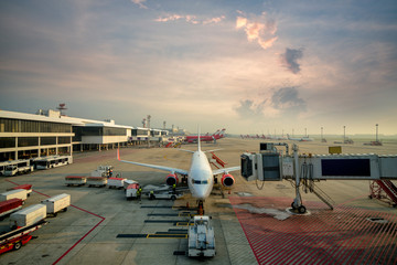 Modern passenger airplane parked to terminal building gate at international airport.