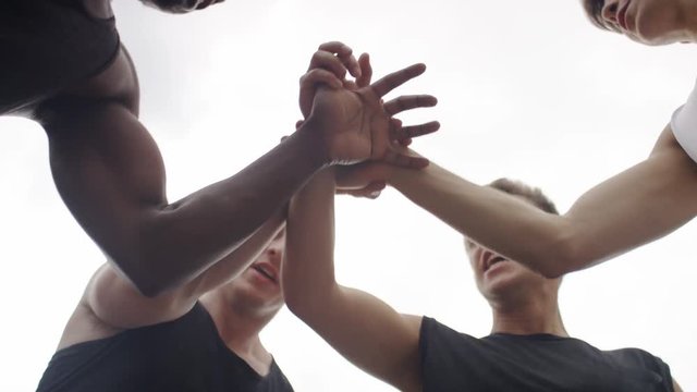 Group Of Sports Men Put Their Hands Together In A Huddle