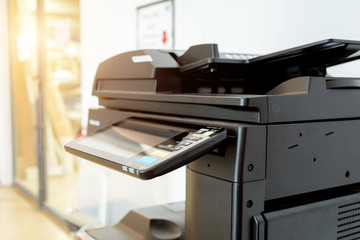 Close up paper sheets on the printer in office room.