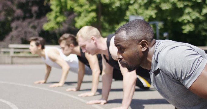 Group of healthy young men working out in a playground, in slow motion