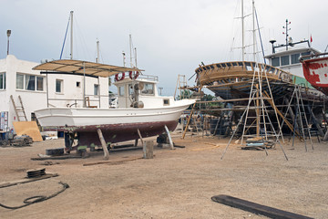 Fototapeta na wymiar Fishing boats, wooden boats and ships on the lift in a shipyard in Bodrum, Turkey