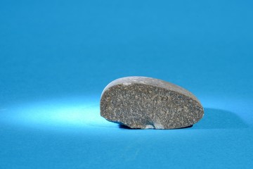 Zerbrochener Kieselstein mit blauem Hintergrund