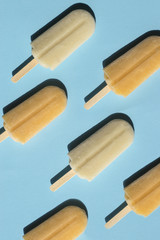 Varying  popsicles on a turquoise background. Flat lay of summer sweets in pop-art style. Vertical format