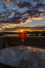 Glasse of wine in the background landscape with dramatic sky during sunset in Lake Taupo, New Zealand