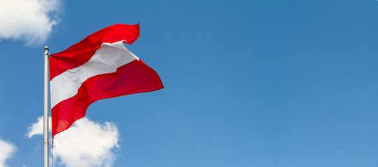 Flag of Austria waving in the wind on flagpole against the sky with clouds on sunny day, banner, close-up - obrazy, fototapety, plakaty