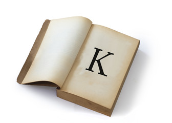 K letter on open old book