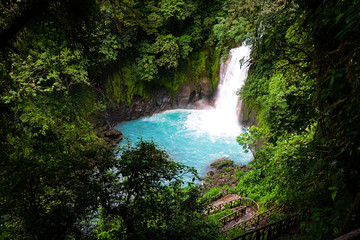 Naklejka na ściany i meble Jungle of Costa Rica waterfall. The river (rio celeste in tenorio national park close to Bijagua) has an emerald green color, caused by volcanic minerals