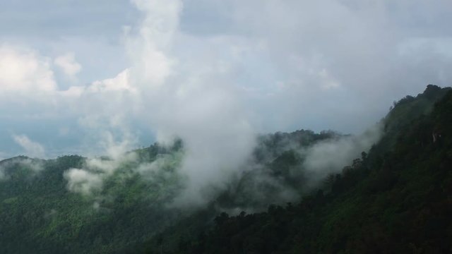 Misty valley and layers of tropical mountain With Wind turbine on top at Phu Hin Rong Kla National Park , Thailand.