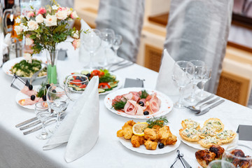 Beautifully decorated catering banquet table with different food snacks and appetizers on corporate birthday party event or wedding celebration