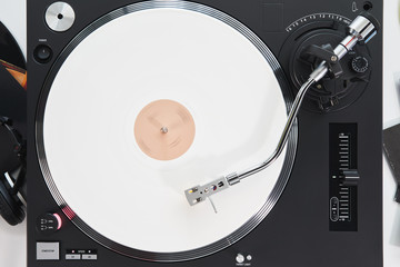 Turntable vinyl record player on the background white wooden boards. Sound technology for DJ to mix...