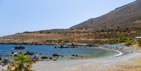 Summer trip to the island of Crete, Greece. Rocky and stony coast. Dream view of the waves, rocks and deep blue sea. The Mediterranean coast.