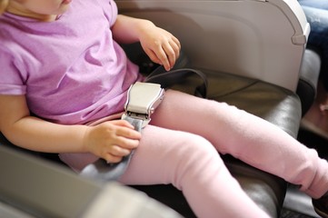 the little girl sits in a passenger chair of the plane