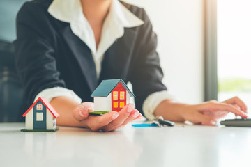 Women Real Estate Agent hold a small house model in her hand ,Real estate Concept