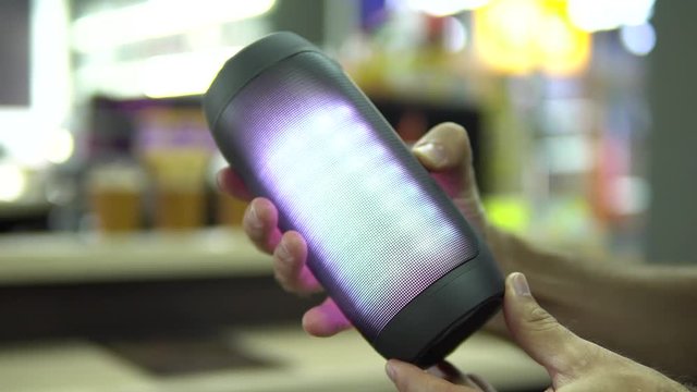 Portable speaker glows in hand.