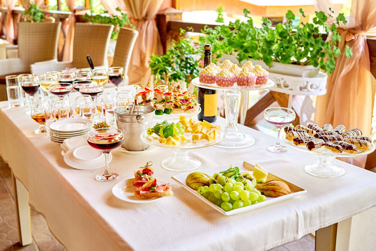 Buffet Table With Champagne, Wine, Snacks, Canape, Sandwiches, Sweets And Appetizers At Luxury Wedding Reception Outdoors, Copy Space. Serving Food And Drinks At Event. Catering Banquet Table