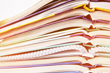 Educational school books lie one on one on a white background. The concept of back to school