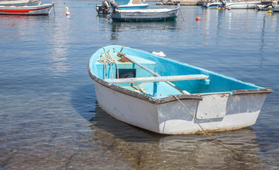 Fototapeta na wymiar Typical boat above the crystal clear water. The non motorized sea vehicle docks in the shallow area of the seaside. Fishing machinery and mode of transportation.