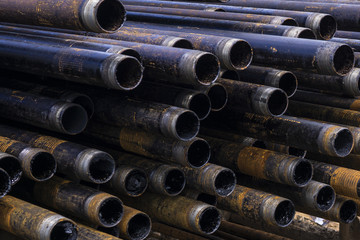 Oil Drill pipe. Rusty drill pipes were drilled in the well section. Downhole drilling rig. Laying the pipe on the deck. View of the shell of drill pipes laid in courtyard of the oil and gas warehouse.