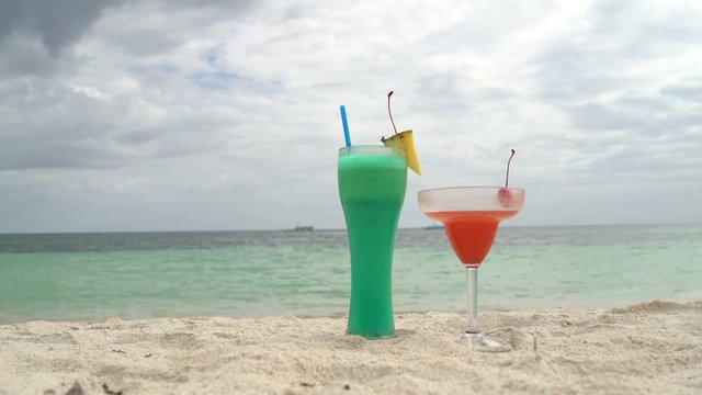 Cocktails are on the sand next to the sea