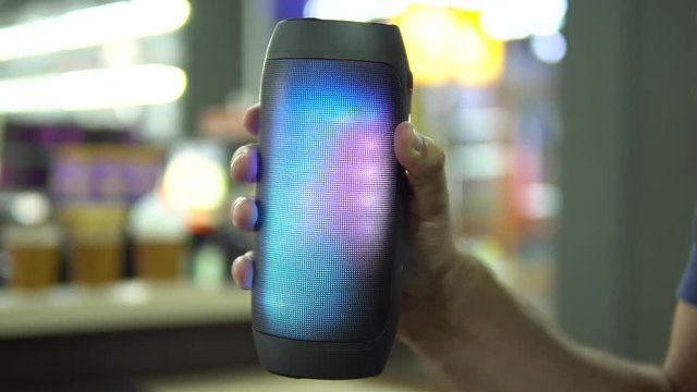 Portable speaker glows in hand.