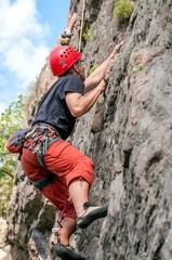 Rock climbing. A young climber climbs a vertical granite rock. Extreme sport.