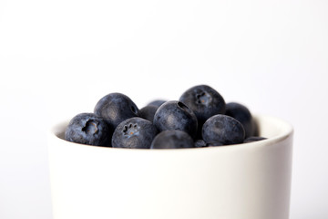 selective focus of blueberries in bowl isolated on white background