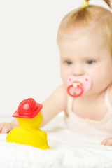 
Studio portrait of adorable baby girl playing with yellow rubber duck, isolated on the white background, summer vacation concept