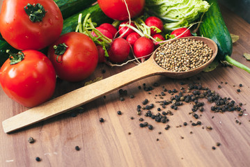 Fresh vegetables tomatoes, cucumbers, and spices on wooden background. Copy space