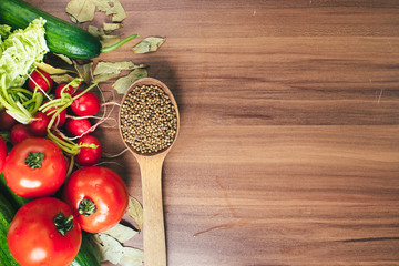 Fresh vegetables tomatoes, cucumbers, and spices on wooden background. Copy space