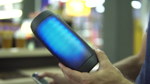 Portable speaker glows in hand.