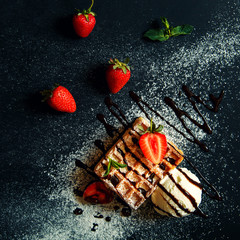 Belgian waffles with ice cream and strawberries.