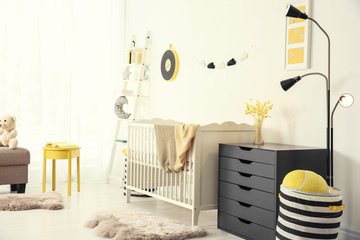 Stylish baby room interior with crib