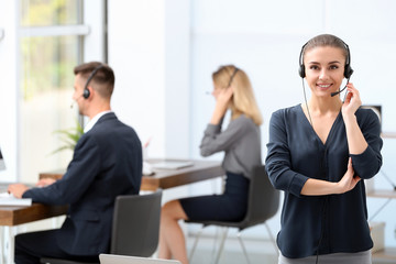 Young female receptionist with headset in office