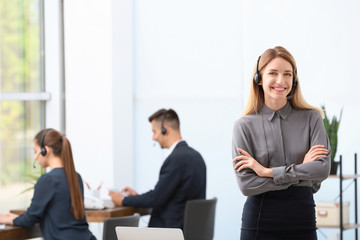 Young female receptionist with headset in office