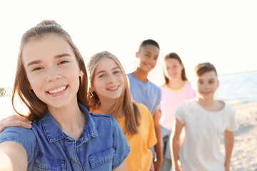 Group of children taking selfie on beach. Summer camp