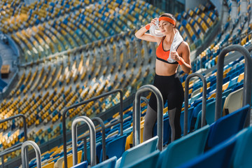 high angle view of tired young woman with towel at sports stadium