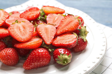Plate with ripe strawberries on table, closeup