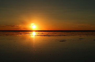Stunning sunset reflection on the flooded Uyuni Salt Flats of Bolivia, South America 