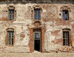 Fototapeta na wymiar Old broken facade of the large house with wooden frame windows