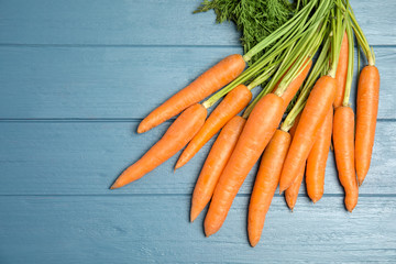 Ripe carrots on wooden background, top view