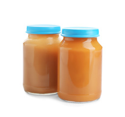 Jars with healthy baby food on white background