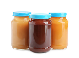 Jars with healthy baby food on white background
